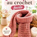 Écharpe au crochet en laine grise posée sur une table en bois.
