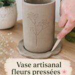 Vase en céramique décoré avec des fleurs pressées, présent dans une ambiance chaleureuse.